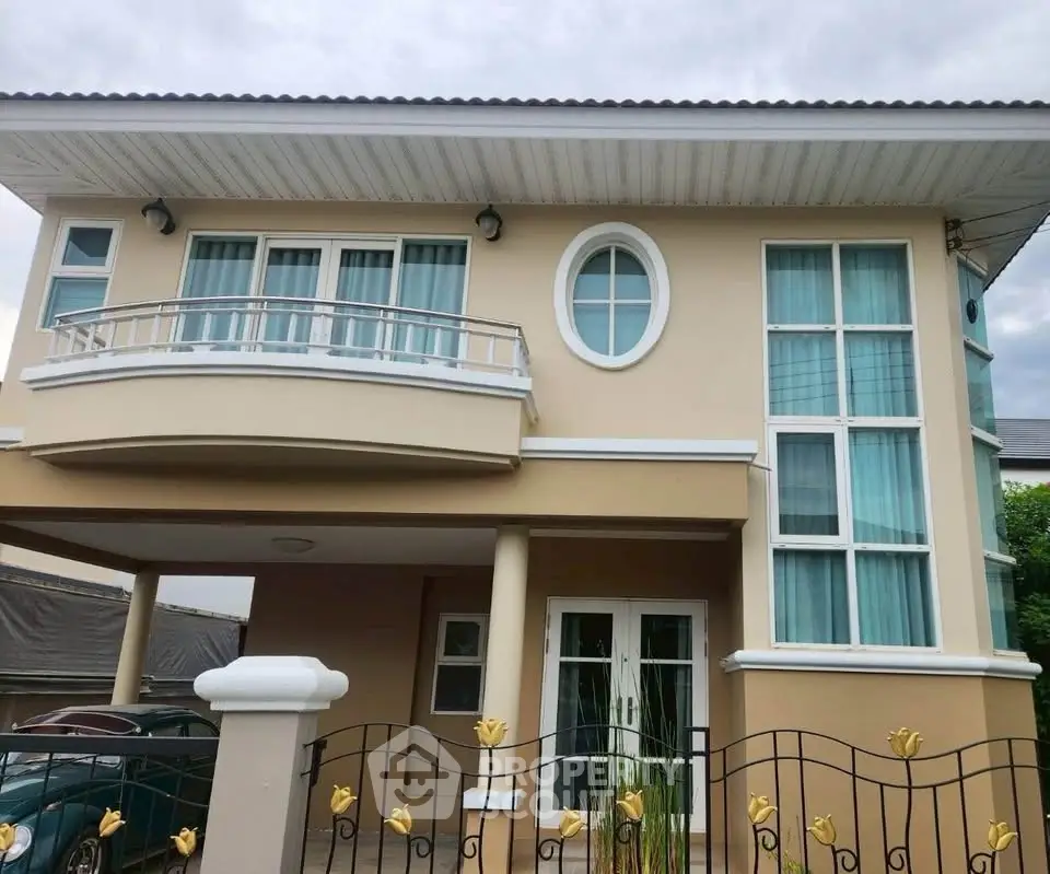 Elegant two-story house with unique circular window and spacious balcony