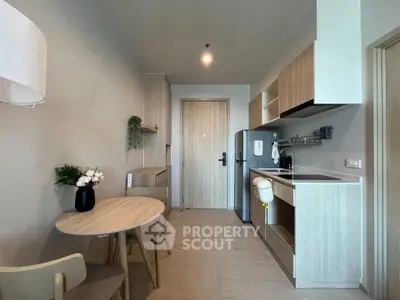 Modern kitchen with wooden cabinets and dining area in a cozy apartment.