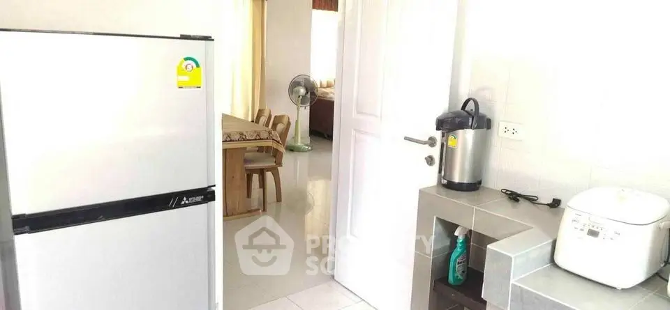 Modern kitchen with appliances and dining area in a bright, open layout.
