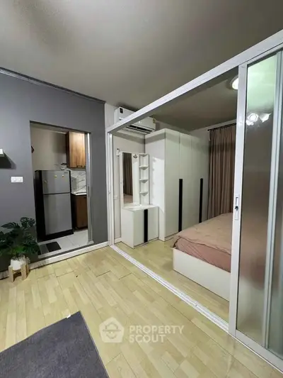 Modern studio apartment with sliding glass doors and compact kitchen