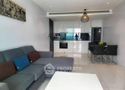 Modern open-plan living room with sleek kitchen and stylish decor in a contemporary apartment.