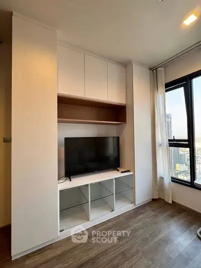 Modern living room with built-in TV cabinet and large window view