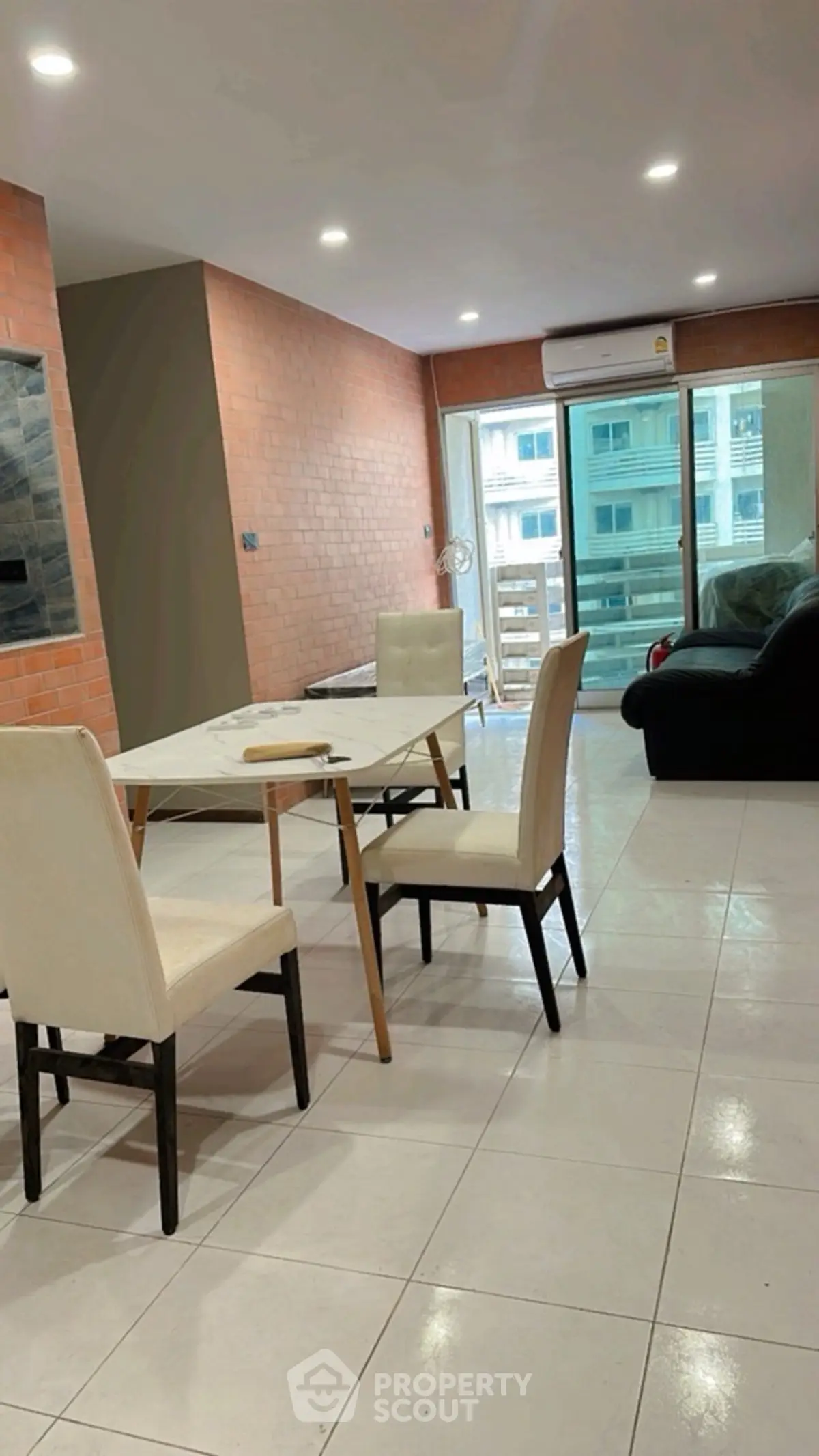 Spacious living room with modern furniture and balcony view in urban apartment.