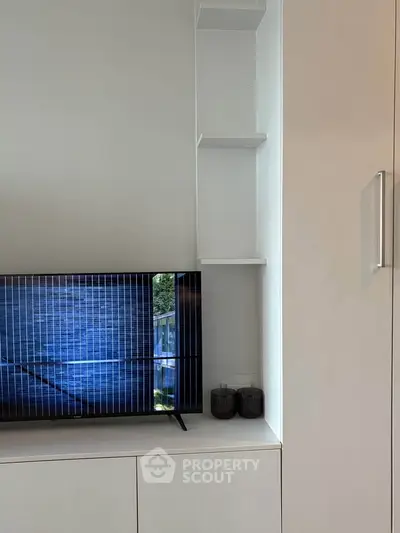 Modern living room with sleek TV and minimalist shelving