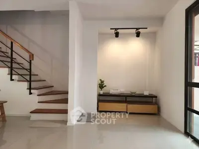 Modern interior with sleek staircase and minimalist decor in a bright living space.