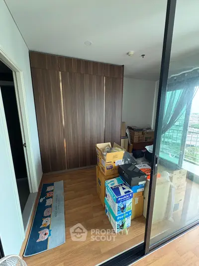 Spacious room with wooden flooring and large wardrobe, ideal for storage or conversion.