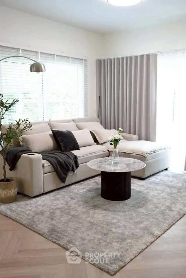 Elegant living room with modern sofa, chic coffee table, and stylish decor in a bright, airy space.