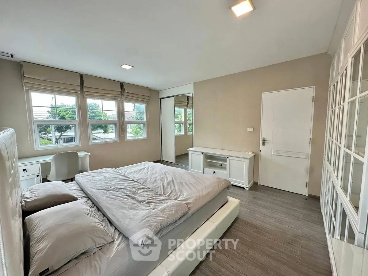 Spacious bedroom with large windows and modern furnishings