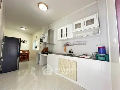 Modern kitchen with sleek white cabinets and dining area in open layout