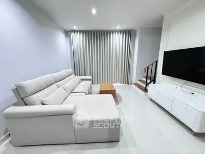 Modern living room with sleek furniture and large TV, perfect for relaxation.
