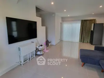 Spacious modern living room with large TV and sleek furniture