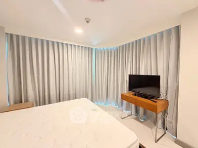 Spacious bedroom with modern furnishings and large windows, perfect for comfort and relaxation.