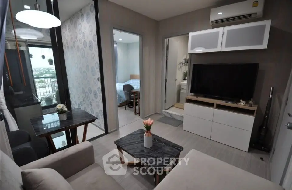 Modern living room with stylish decor and open view, featuring cozy seating and sleek entertainment unit.