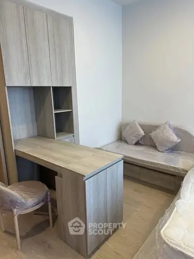 Modern study room with built-in desk and cozy seating area in stylish apartment.