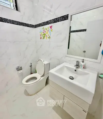 Modern bathroom with sleek white tiles and contemporary fixtures