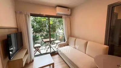 Cozy living room with balcony view, featuring a comfortable sofa and modern decor.