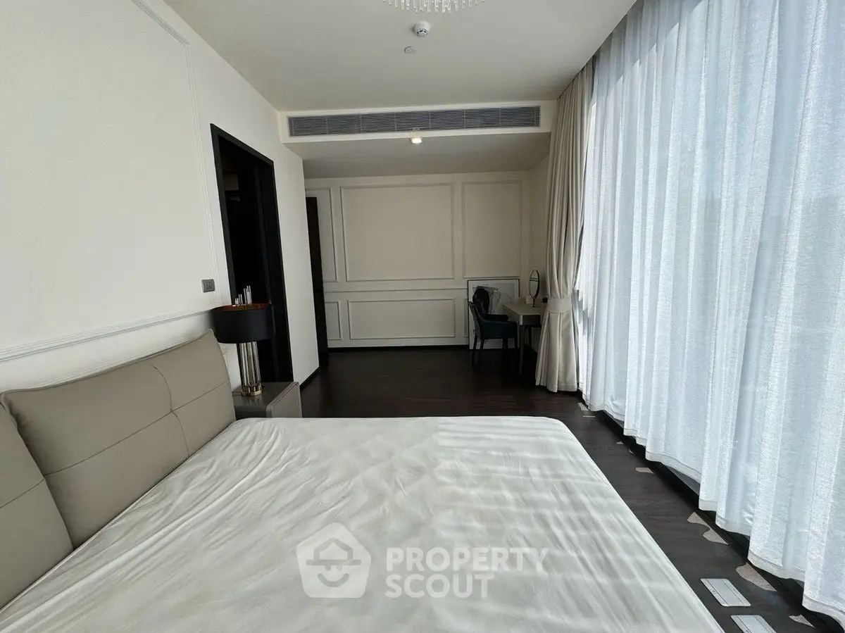 Spacious bedroom with elegant decor and large windows for natural light