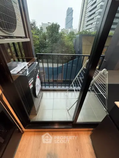 Modern balcony with washing machine and drying rack in urban apartment