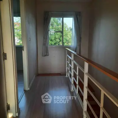 Bright hallway with wooden flooring and window view in modern home