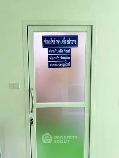 Frosted glass door with blue signage in a clean, well-lit interior space.