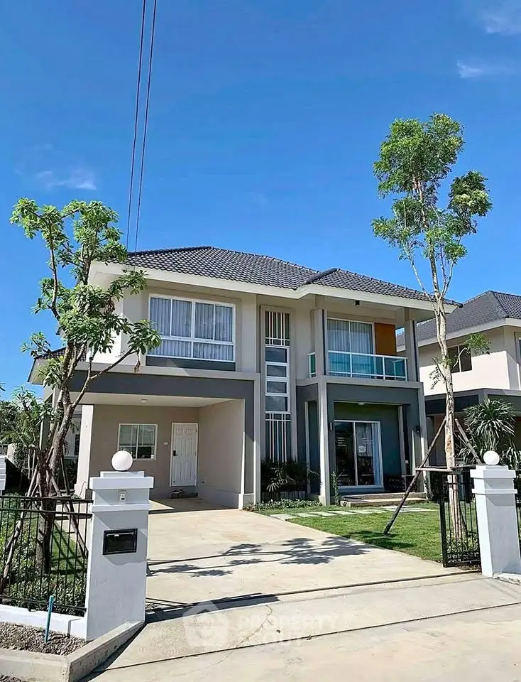 Modern two-story house with spacious driveway and lush greenery