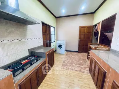 Spacious kitchen with gas stove and washing machine in modern home