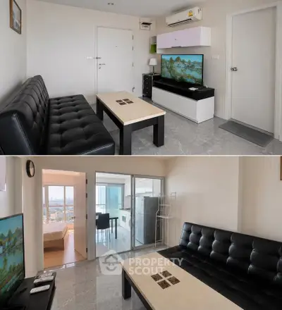 Modern living room with sleek black sofa, TV, and open view to bedroom and kitchen.
