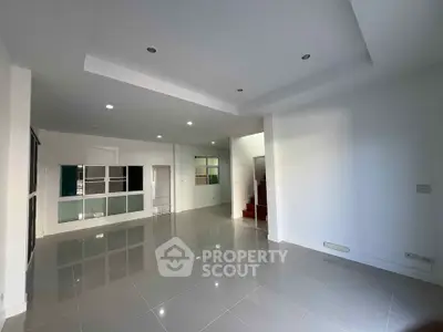Spacious modern living room with glossy tiled floors and recessed lighting
