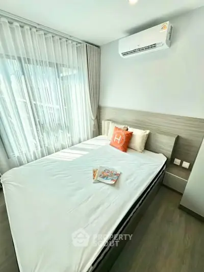 Bright and cozy bedroom with modern air conditioning and elegant decor, perfect for relaxation.