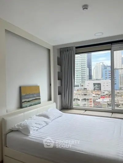 Modern bedroom with large window offering city skyline view, featuring a comfortable bed and minimalist decor.