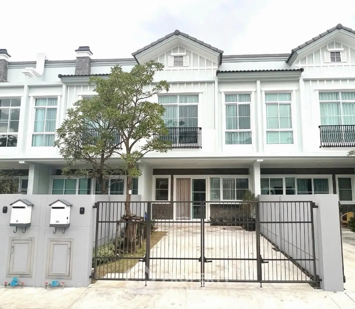 Charming townhouse with modern facade and gated entrance in a serene neighborhood.