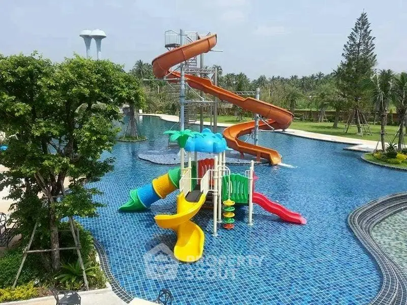 Luxurious outdoor pool with vibrant water slides in a tropical resort setting.