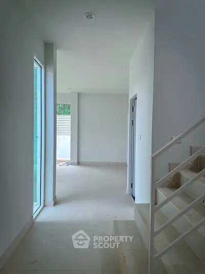 Spacious modern interior with natural light and sleek staircase, perfect for contemporary living.