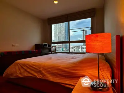 Cozy bedroom with city view and warm lighting, perfect for relaxation.