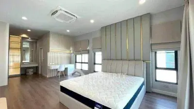 Spacious modern bedroom with elegant decor and large windows for natural light.