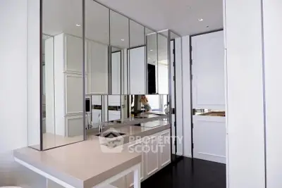 Modern kitchen with sleek cabinetry and mirrored backsplash
