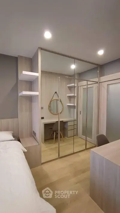 Modern bedroom with mirrored wardrobe and stylish desk, perfect for urban living.