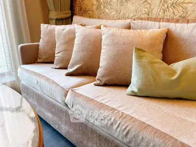 Elegant living room with plush beige sofa and stylish cushions, perfect for relaxation and comfort.