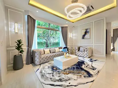 Luxurious living room with elegant decor, plush sofas, and large window offering serene garden view.