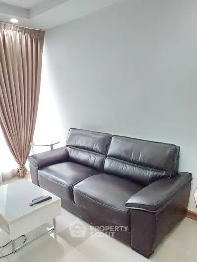 Modern living room with sleek leather sofa and elegant curtains