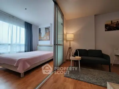 Modern studio apartment with sliding glass partition, cozy living area, and natural light.