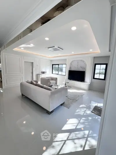 Luxurious modern living room with elegant white decor and plush seating.