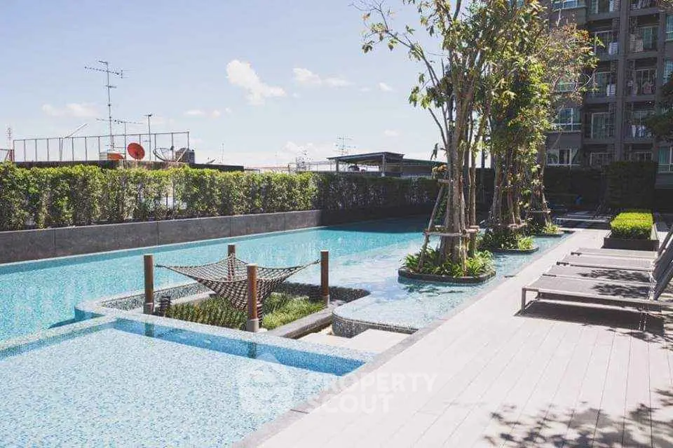 Luxurious outdoor pool area with modern design and lush greenery in a high-end residential complex.