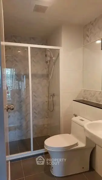 Modern bathroom with glass shower enclosure and sleek fixtures