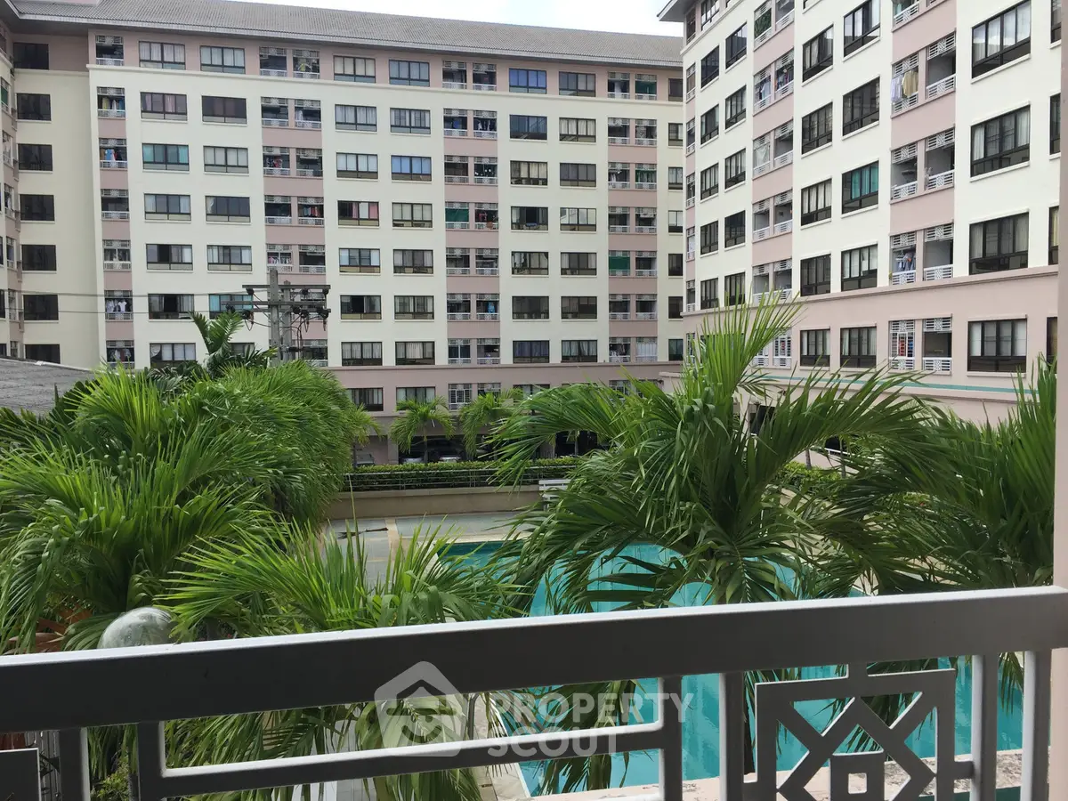 Modern apartment complex with lush greenery and inviting pool view.