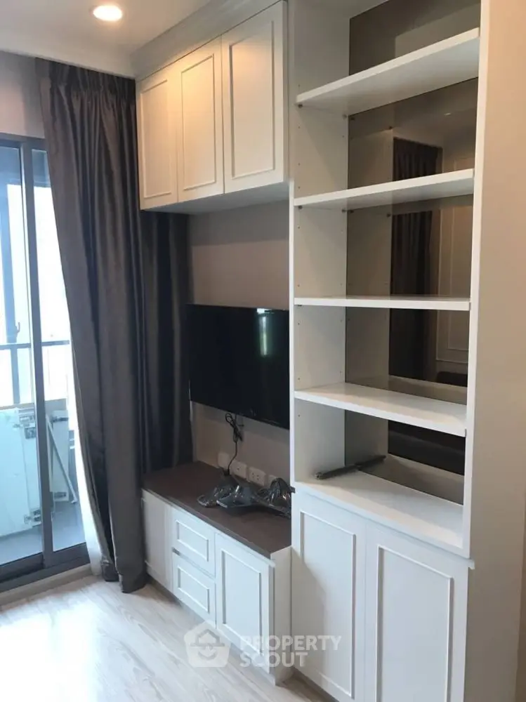 Modern living room with built-in shelving and balcony access