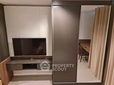 Modern living room with sleek TV setup and stylish furniture in contemporary apartment.