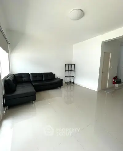 Spacious modern living room with sleek black sofa and minimalist decor