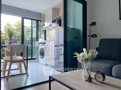Modern apartment with open kitchen, washing machine, and balcony view.