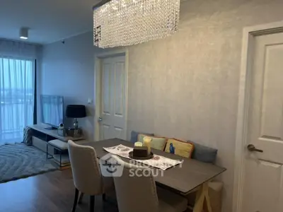 Modern dining and living area with elegant chandelier and cozy decor